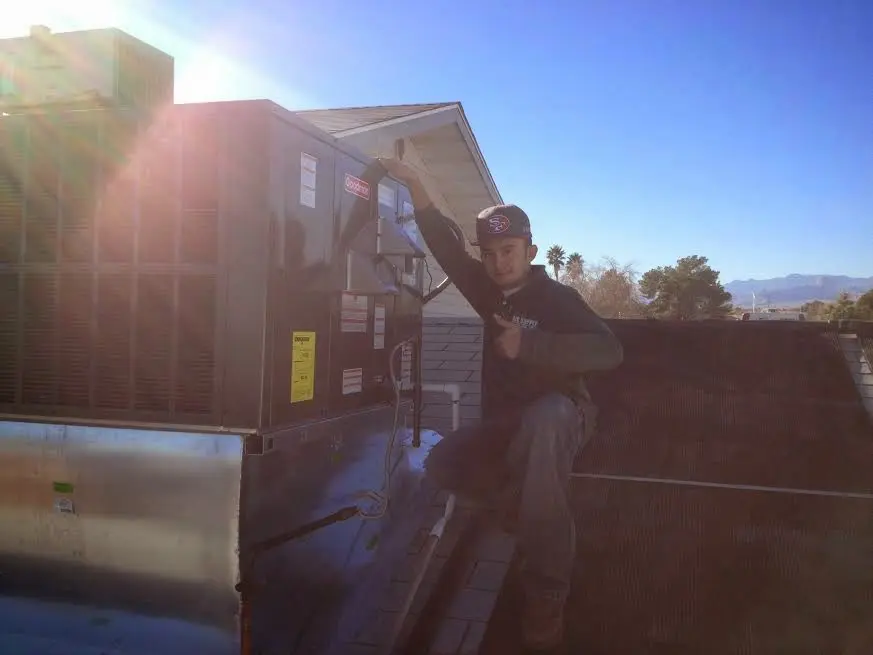 HVAC technician performing Air Duct Repair on a rooftop unit in Gardner